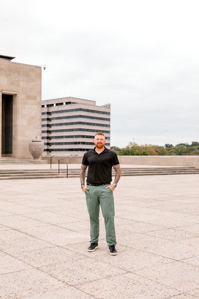 Michael Morris today: full-body professional portrait in black polo and green pants